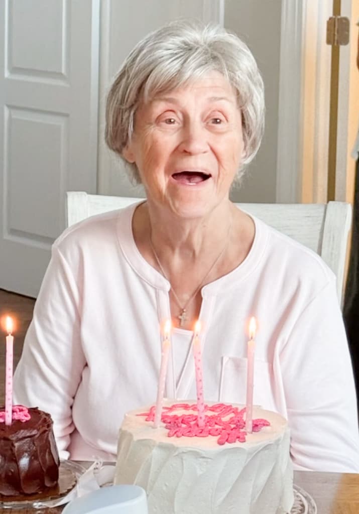 Patricia smiling behind a birthday cake